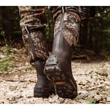 Outdoor worker wearing Muck Woody Max Knee Boots Men's Size 11 in muddy field conditions